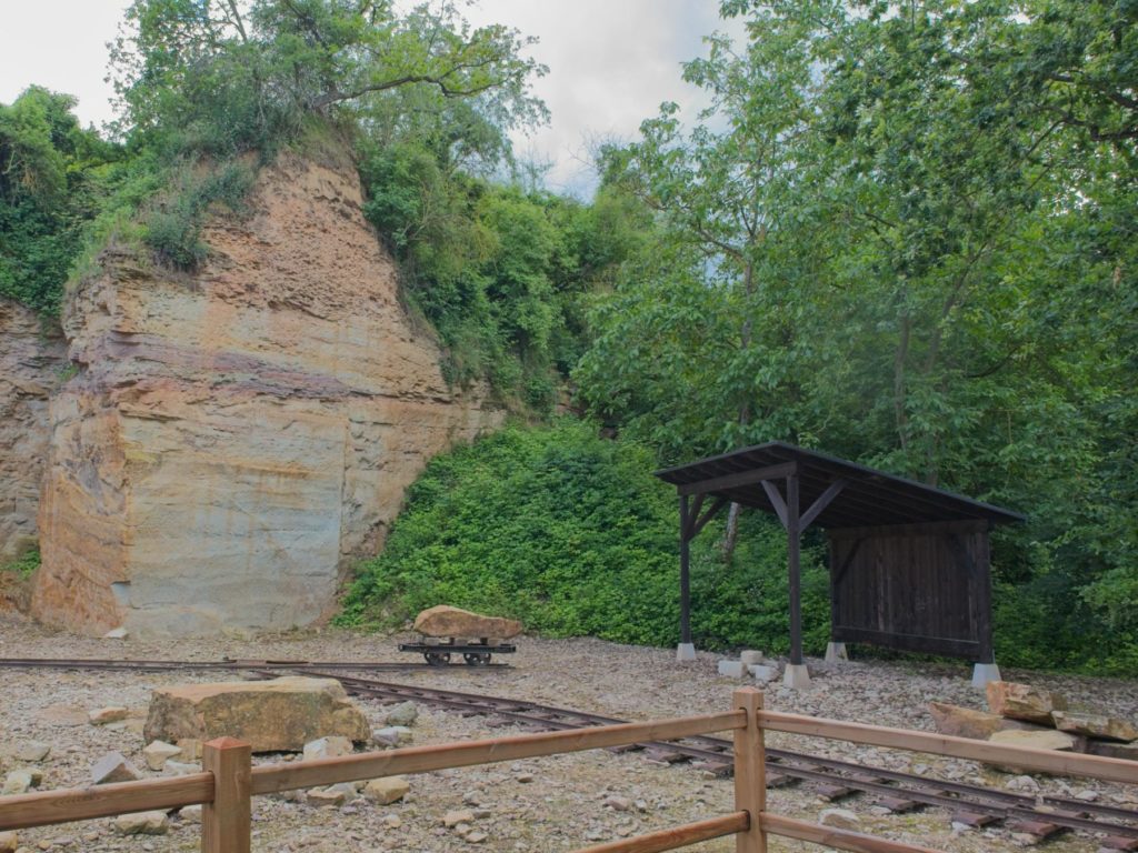 Narrow-gauge rails, trolley and processing shelter in the SCHAU quarry in Flonheim