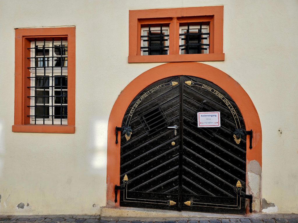 Historischer Kellereingang mit kunstvoll verziertem Holztor in Oppenheim – Zugang zum berühmten Kellerlabyrinth.