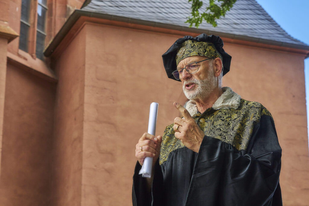 „Magister“ Jürgen Franz takes the guests back to the time of the town's elevation and looks at the beginnings of the settlement of Oppenheim.