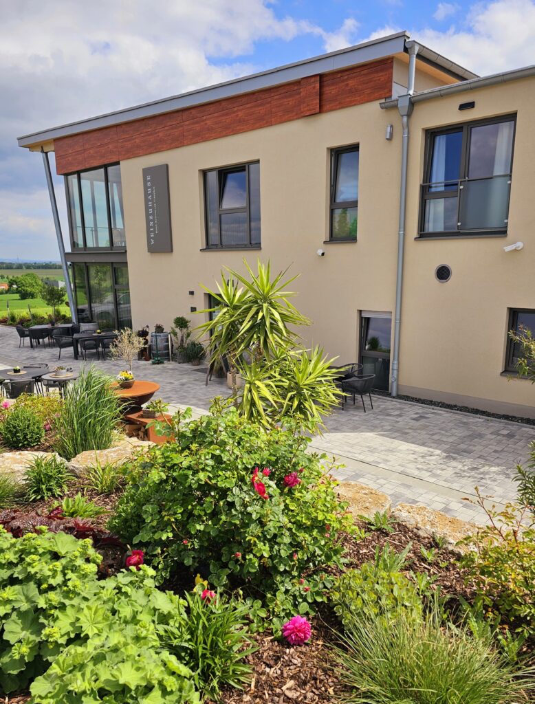 Blühender Garten am Weinzuhause mit mediterraner Bepflanzung und Terrasse